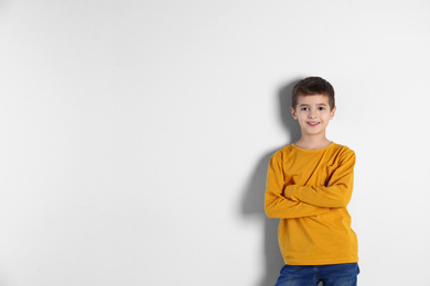 Portrait of cute little boy on light background, space for text