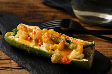 Baked stuffed zucchini served on wooden table, closeup