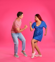 Beautiful lovely couple dancing on pink background