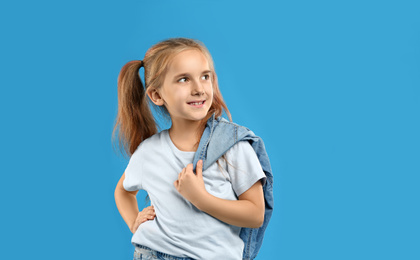 Cute little girl posing on blue background