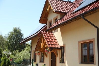 Photo of Exterior of beautiful house with red roof on sunny day