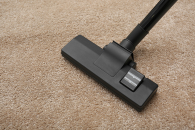 Removing dirt from carpet with modern vacuum cleaner indoors