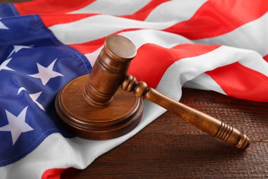 Judge's gavel and American flag on wooden table
