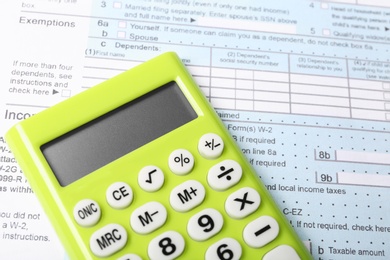Green calculator on document, closeup view. Tax accounting