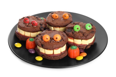 Delicious desserts decorated as monsters on white background. Halloween treat