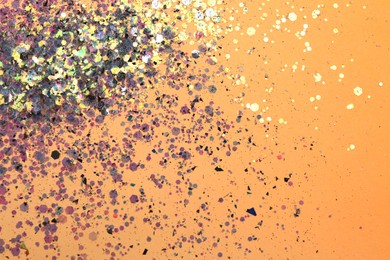 Photo of Shiny bright violet glitter on beige background, flat lay