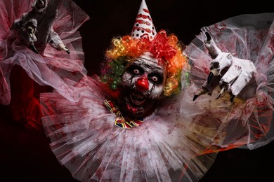 Terrifying clown on dark background. Halloween party costume