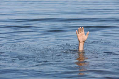 Photo of Drowning man reaching for help in sea, closeup