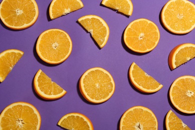 Flat lay composition with fresh ripe oranges on purple background