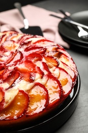 Delicious cake with plums on grey table, closeup