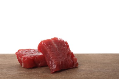 Pieces of raw cultured meat on wooden table against white background, space for text