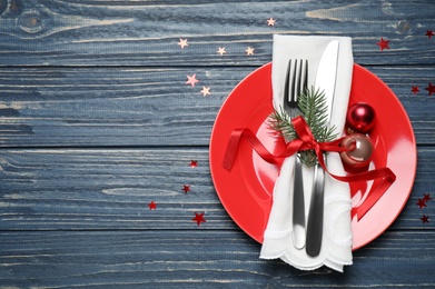 Christmas table setting on blue wooden background, top view. Space for text