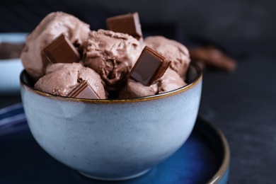 Yummy chocolate ice cream in bowl on table, closeup