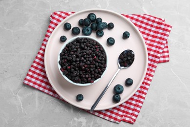 Freeze dried and fresh blueberries on light grey table, top view