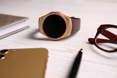 Composition with stylish smart watch on white wooden table, closeup