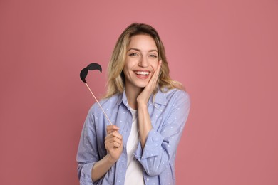 Photo of Funny woman with fake mustache on dusty rose background