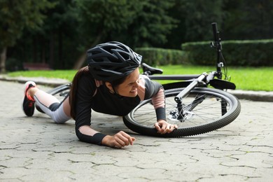 Photo of Young woman fallen off her bicycle in park