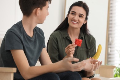 Mother talking with her teenage son about contraception at home. Sex education concept