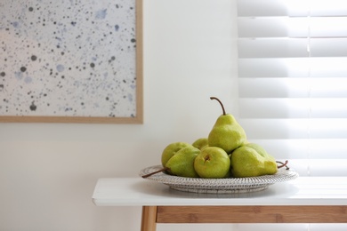 Fresh ripe pears on white table in room. Space for text