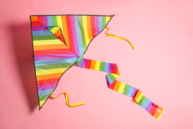 Bright rainbow kite on pink background, top view