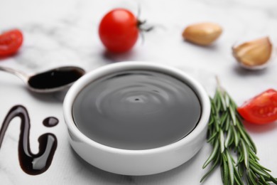 Photo of Organic balsamic vinegar and cooking ingredients on white marble table, closeup