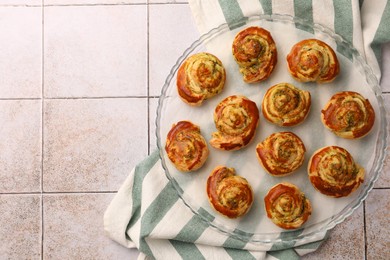 Photo of Fresh delicious puff pastry with tasty filling on white tiled surface, top view. Space for text