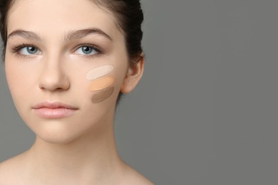 Photo of Beautiful girl on grey background. Using concealers and foundation for face contouring