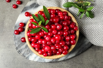 Tasty ripe cranberries on grey table, flat lay