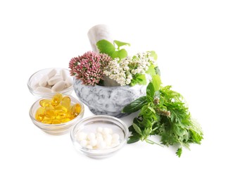 Photo of Marble mortar with fresh herbs and pills on white background