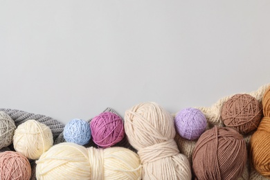 Soft colorful woolen yarns on white background, flat lay. Space for text