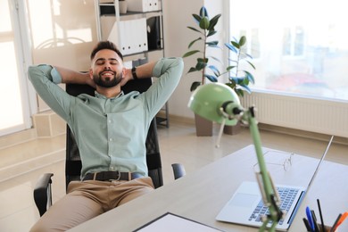 Businessman relaxing in office chair at workplace