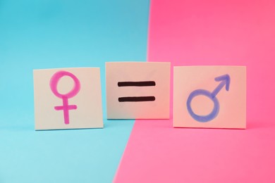 Photo of Gender equality concept. Cards with equal sign and gender symbols on color background