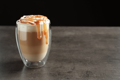 Glass with delicious caramel frappe on table
