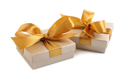 Golden gift boxes with satin bows on white background