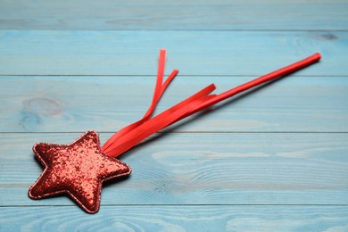 Beautiful red magic wand on turquoise wooden table