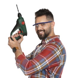 Young man in protective goggles with power drill on white background