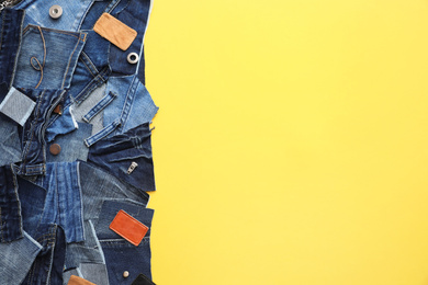 Flat lay composition with patches of old jeans on yellow background. Space for text
