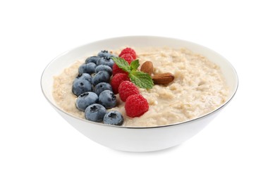 Tasty oatmeal porridge with raspberries, blueberries and almond nuts in bowl on white background