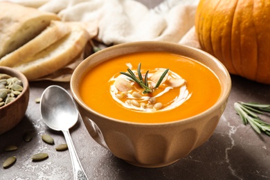 Delicious pumpkin soup in bowl on marble table