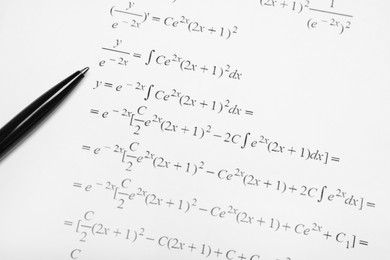 Sheet of paper with mathematical formulas and pen