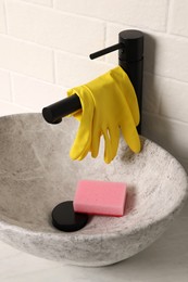 Rubber gloves on faucet in bathroom sink