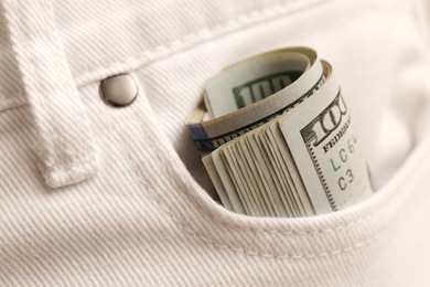 Dollar banknotes in pocket of white jeans, closeup. Spending money