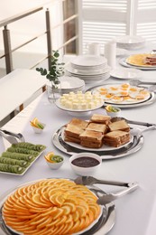 Photo of Different meals for breakfast on white table indoors. Buffet service