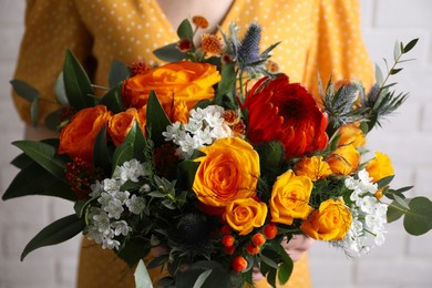 Image of Woman with bouquet of beautiful orange roses, closeup