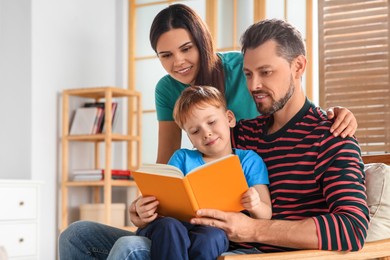 Photo of Happy family reading book together at home