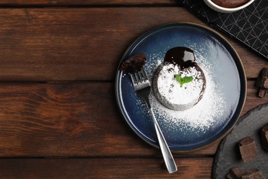 Delicious fresh fondant with hot chocolate and mint on wooden table, flat lay. Space for text