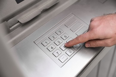 Photo of Man entering cash machine pin code, closeup