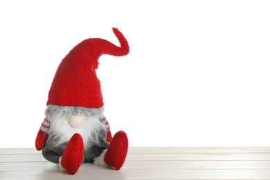Funny Christmas gnome on wooden table against white background. Space for text