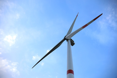 Wind turbine against beautiful blue sky, low angle view. Alternative energy source