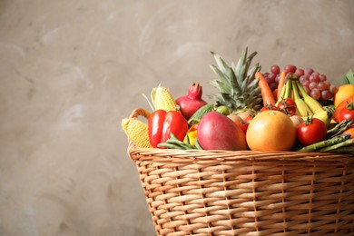 Photo of Assortment of fresh organic fruits and vegetables in basket on grey background, closeup. Space for text